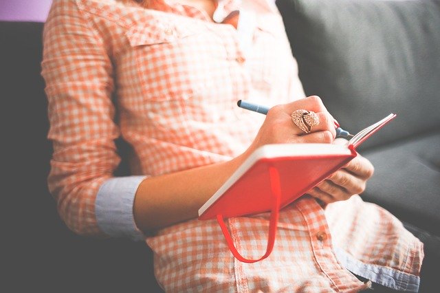 man writing in book